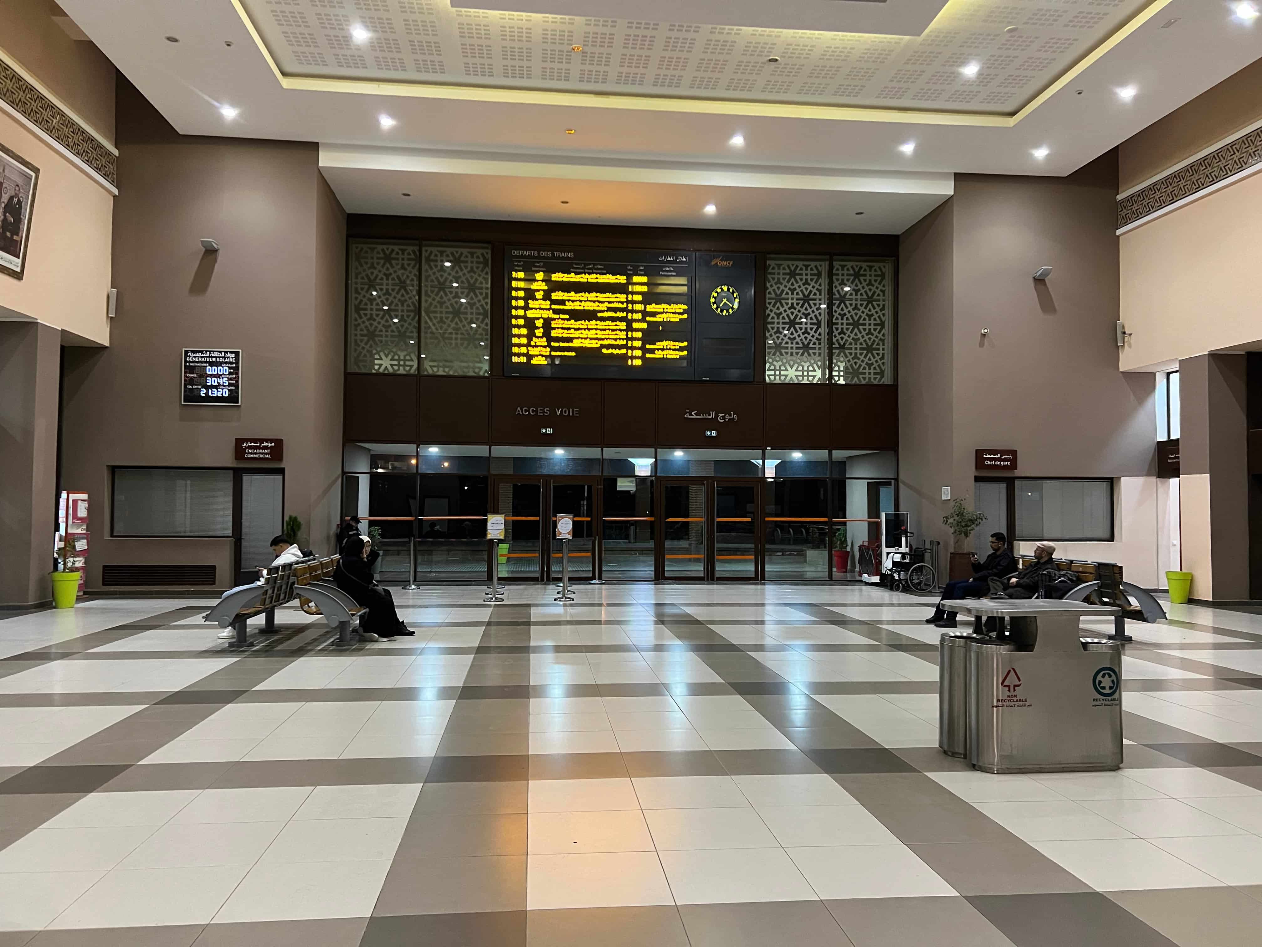 An empty train hall with the schedule board behind