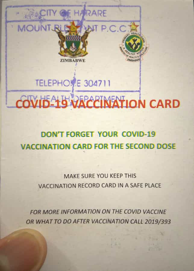 A stamped COVID VACCINATION CARD with Zimbabwe’s coat of arms and MOHCC’s logo, a note to not lose the card and the number for additional information (2019/393)